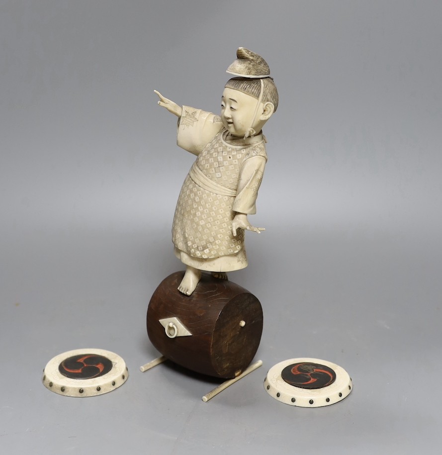 A 19th century Japanese ivory okimono, boy on a barrel with red seal to base, 24cm, together with two carved ivory counters